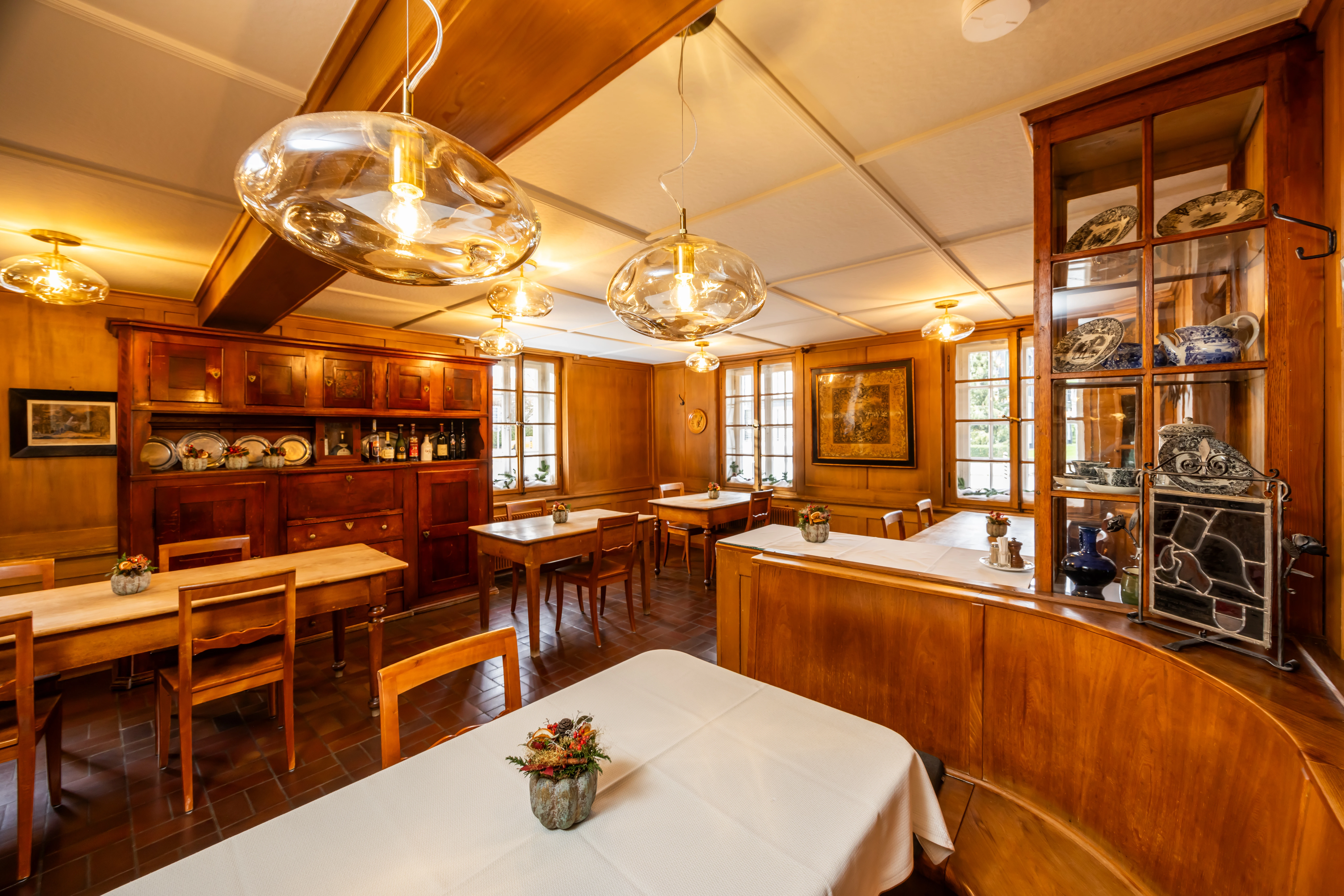 Sala ristorante arredata in stile tradizionale presso il ristorante Sternen, con tavoli in legno, vetrine e luci calde.