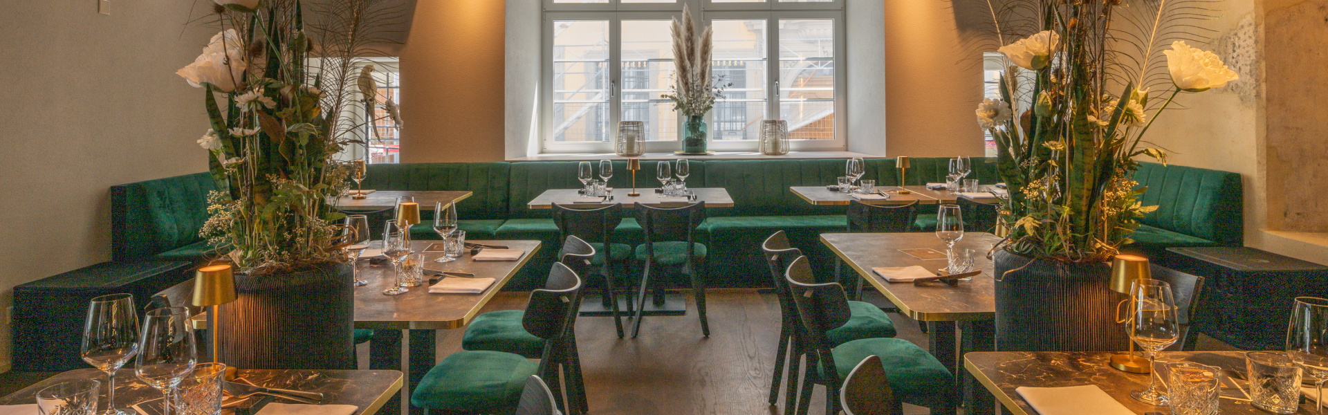 Projektmeeting zu AI-Lösungen im Büro; Gruppe arbeitet an zwei Monitoren, Hand weist auf den Screen neben Tastatur und Tablet.