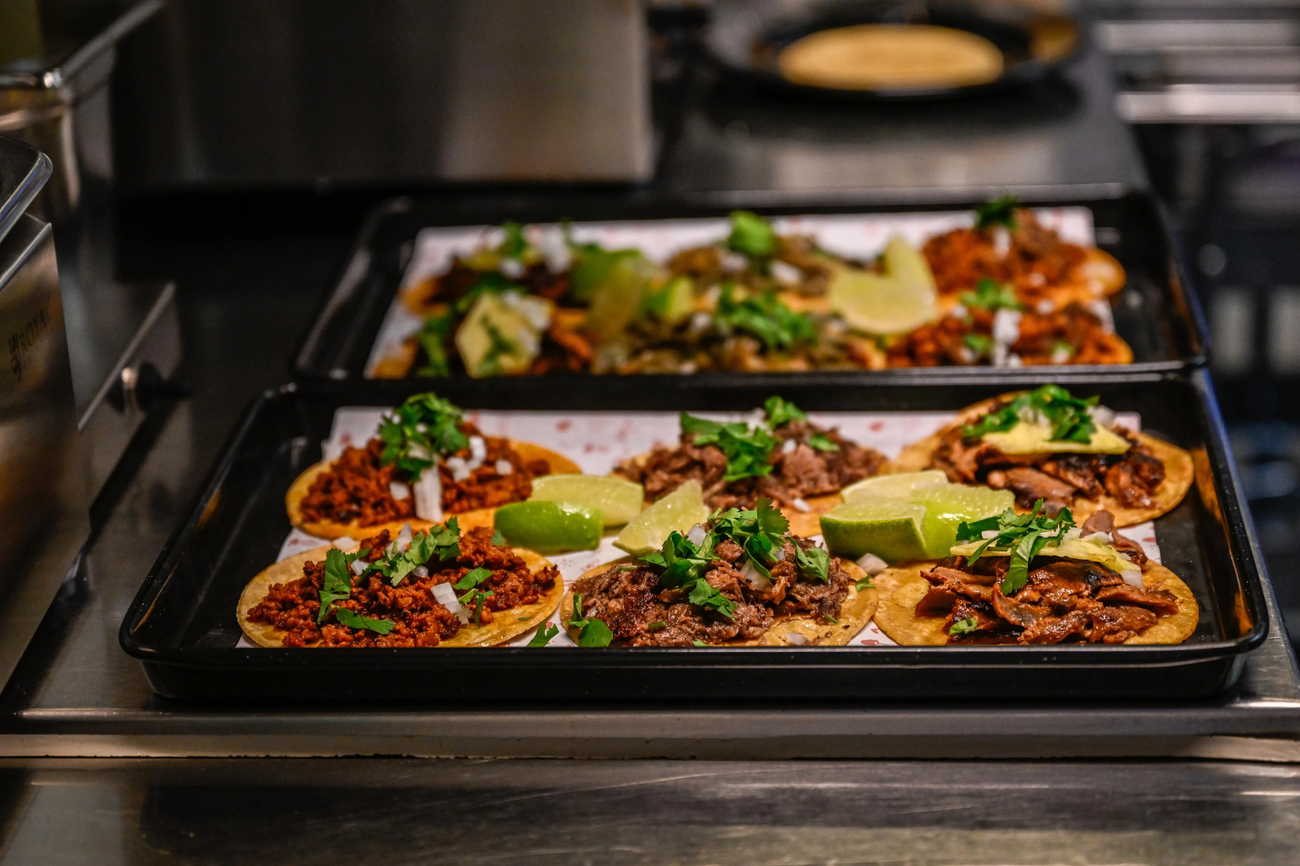 Testo alternativo immagine 2: Tacos appena preparati su due vassoi.